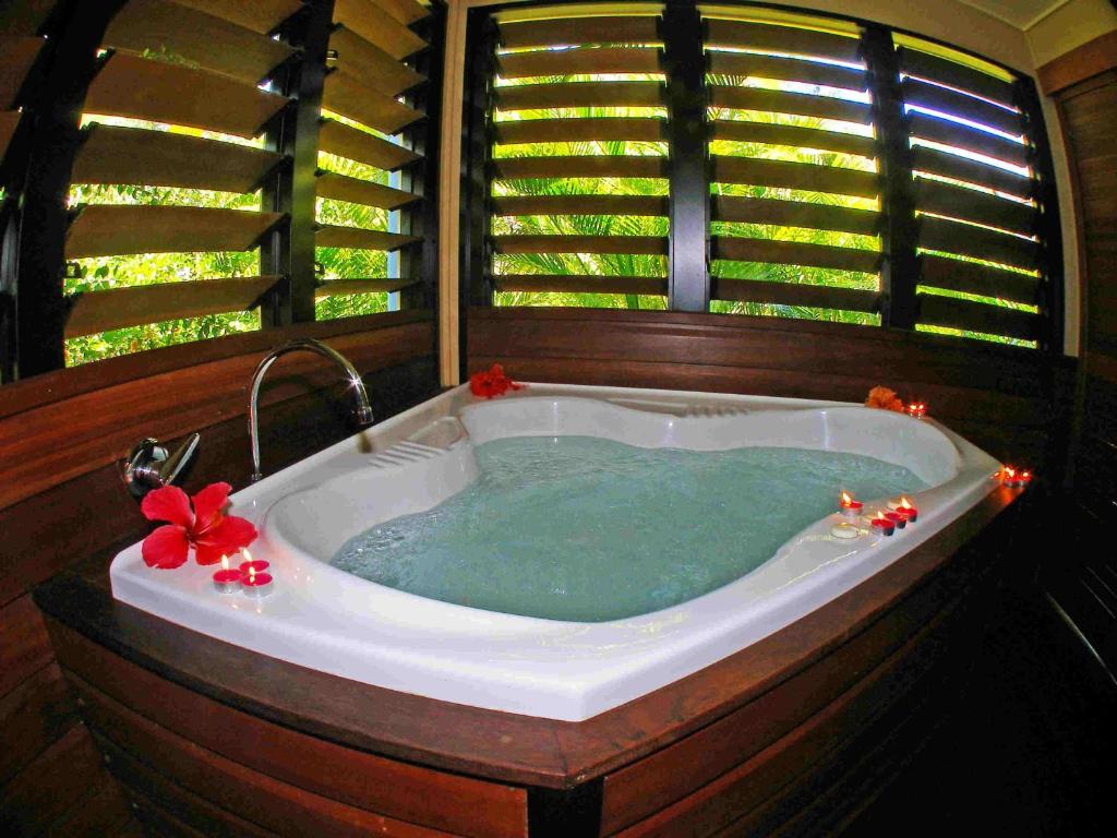 a jacuzzi tub in a room with a window at Sunbird Gardens in Agnes Water