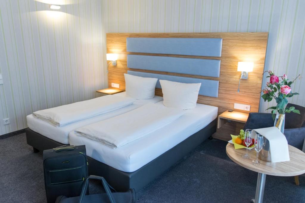 a hotel room with a bed and a table at Seehotel Forst in Forst