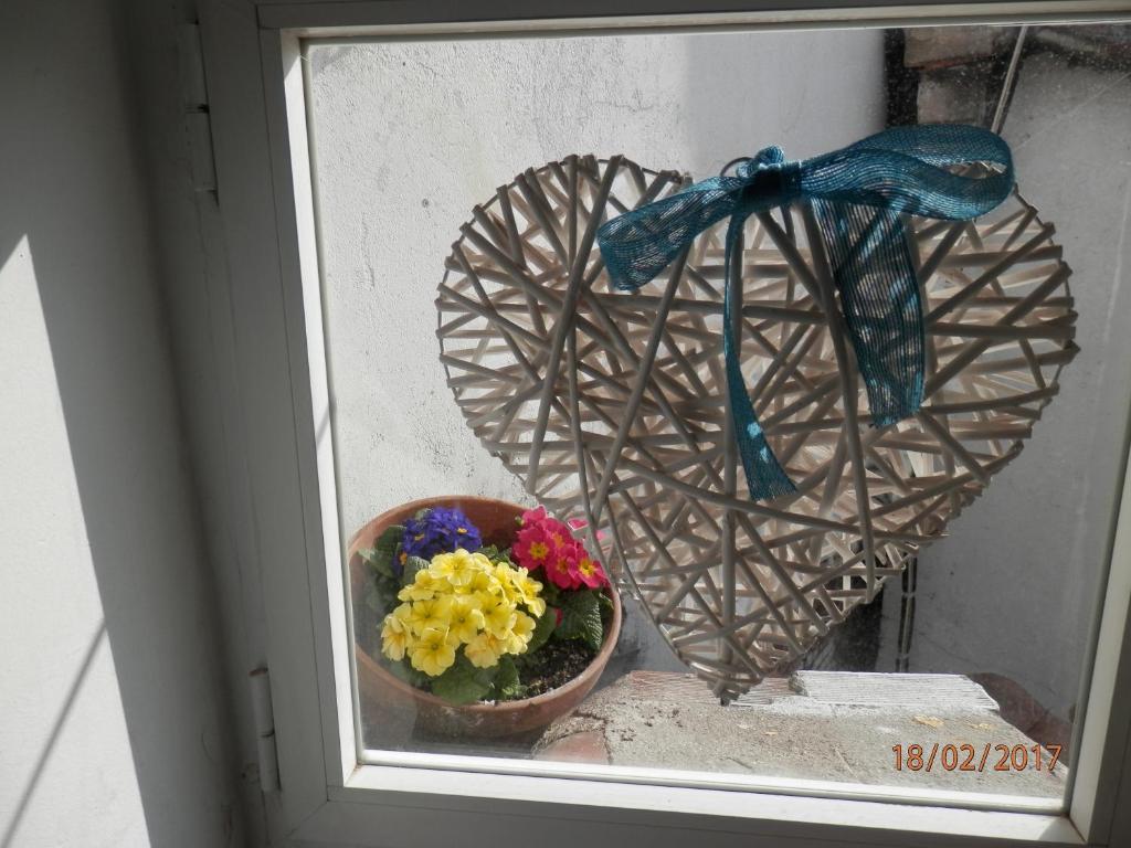 una ventana con un corazón y un jarrón de flores en Buhardilla Corazon de Malasana, en Madrid