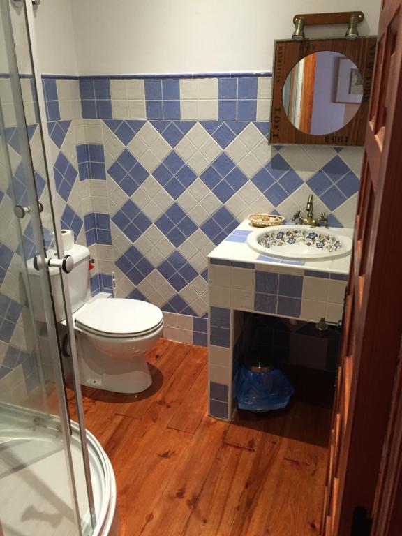 a bathroom with a toilet and a sink and a mirror at Hotel Rural LaEncomienda in Villarramiel