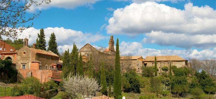 a group of buildings and trees in a field at La Cartuja de Cazalla in Cazalla de la Sierra