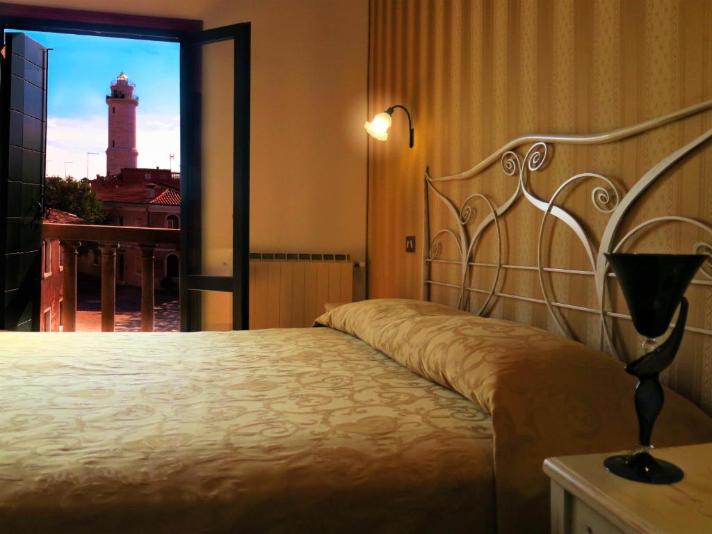 a bedroom with a bed with a view of a lighthouse at Al Soffiador in Murano