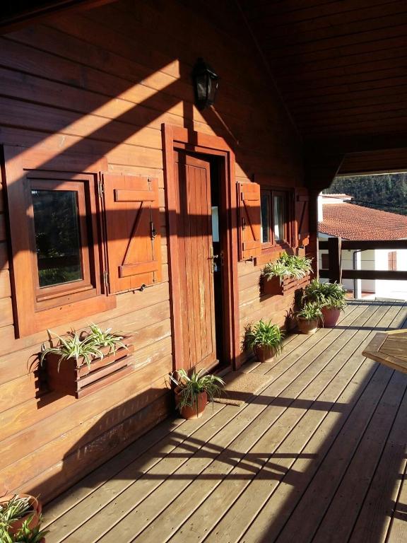 a wooden porch with potted plants on a house at Cabana de Santo António in Vila Nova de Cerveira