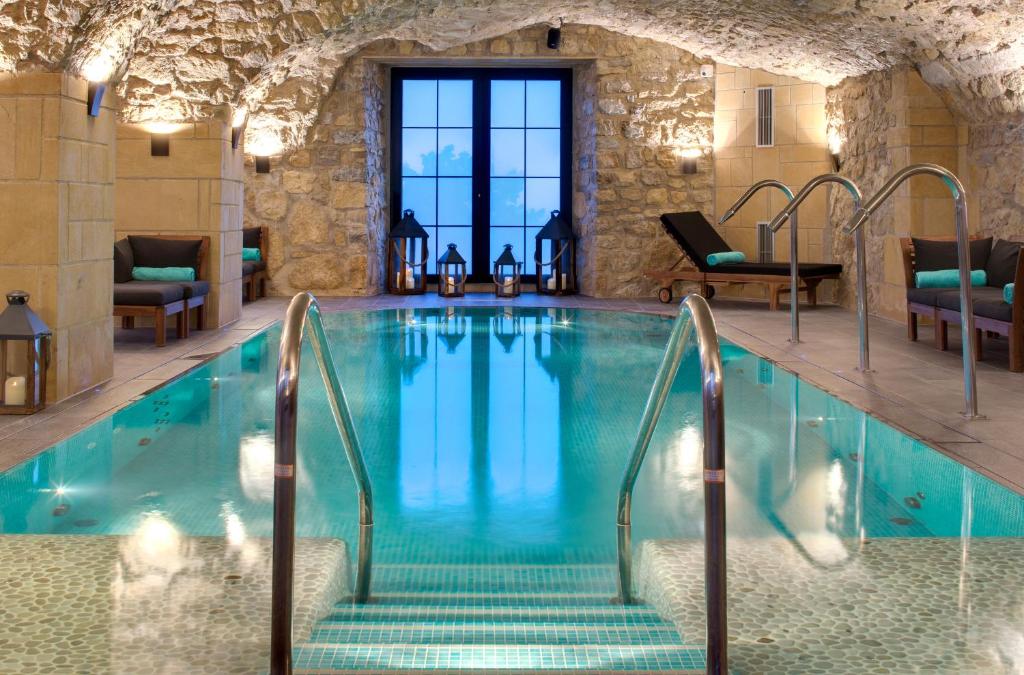 Domaine de la Klauss & Spa, Restaurant Gastronomique Le K في Montenach: حمام سباحة مع سلالم تؤدي إلى مبنى