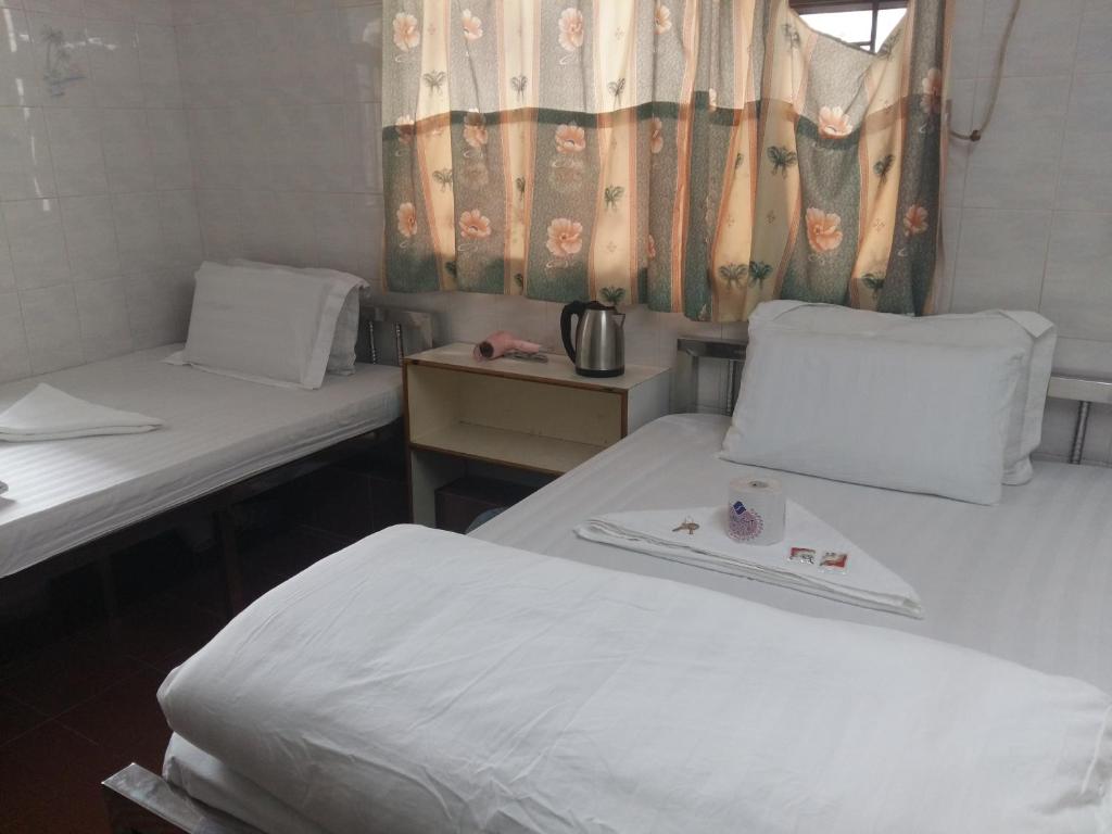 a room with two beds and a window at New Yan Yan Guest House reception 9th floor Flat E4 E6 in Hong Kong