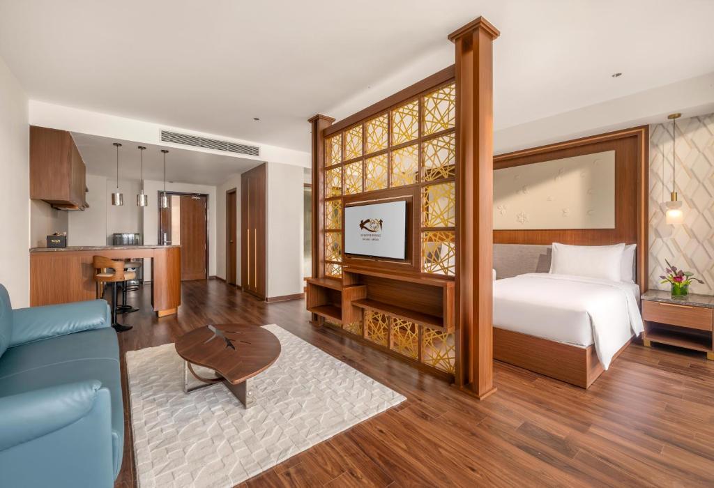 An open-plan suite showing a living room, kitchenette and separate sleeping zone.