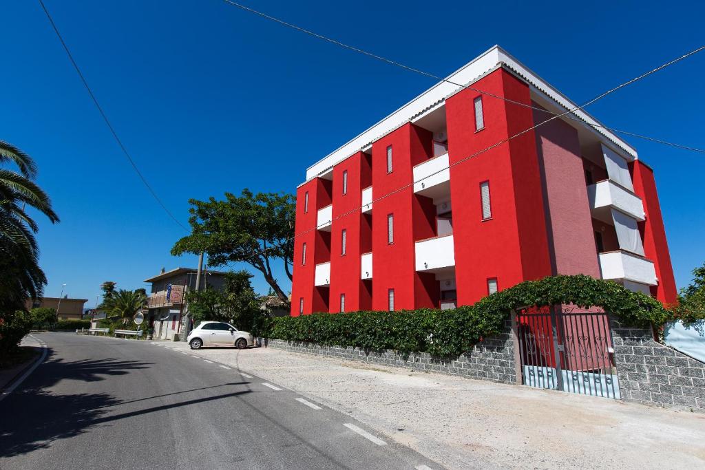 un edificio rojo al lado de una calle en Hotel Villa Susy, en Davoli
