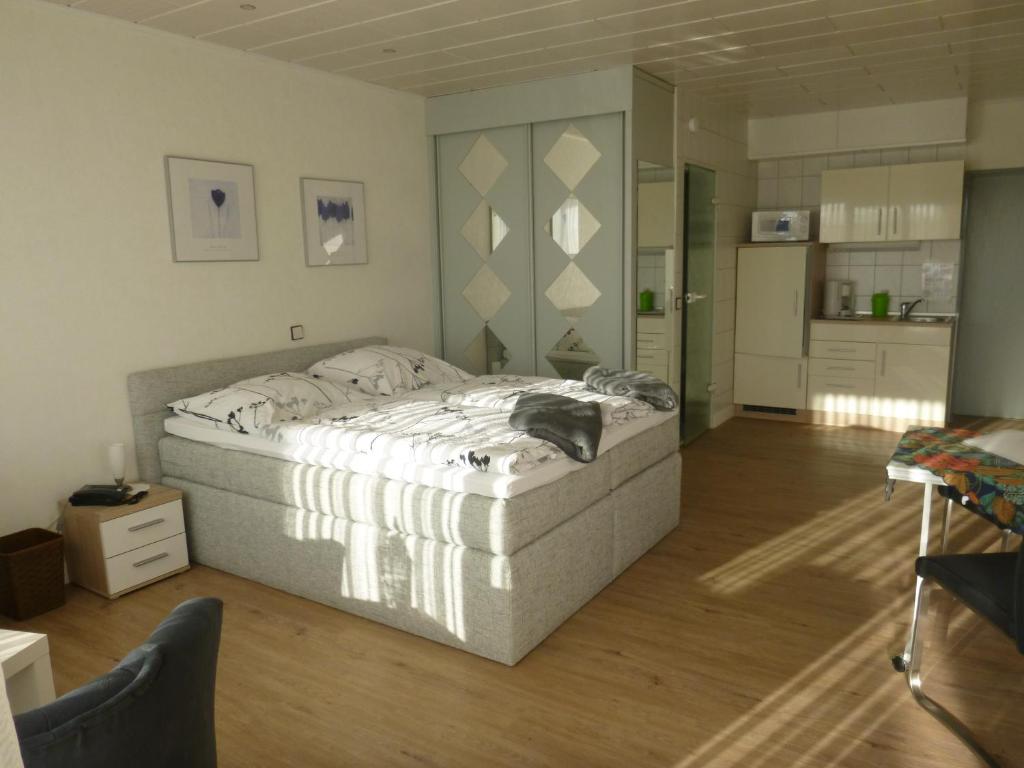 a bedroom with a large bed and a kitchen at Haus Delphin in Bad Wildungen