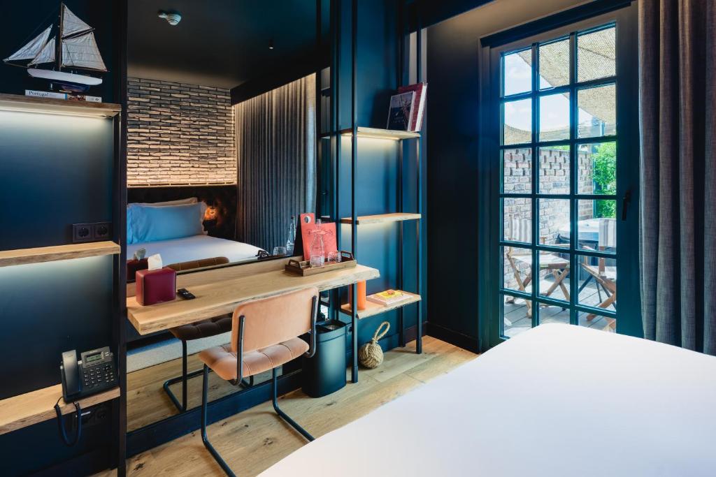 A bedroom workspace facing a glass door and a small outdoor seating area.