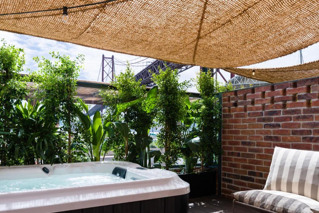 A rooftop hot tub with shaded seating and a distinctive bridge view beyond the plants.