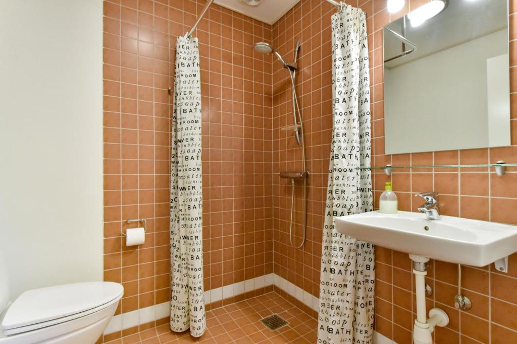 a bathroom with a shower and a toilet and a sink at Skjoldbjerg Garnihotel in Vorbasse
