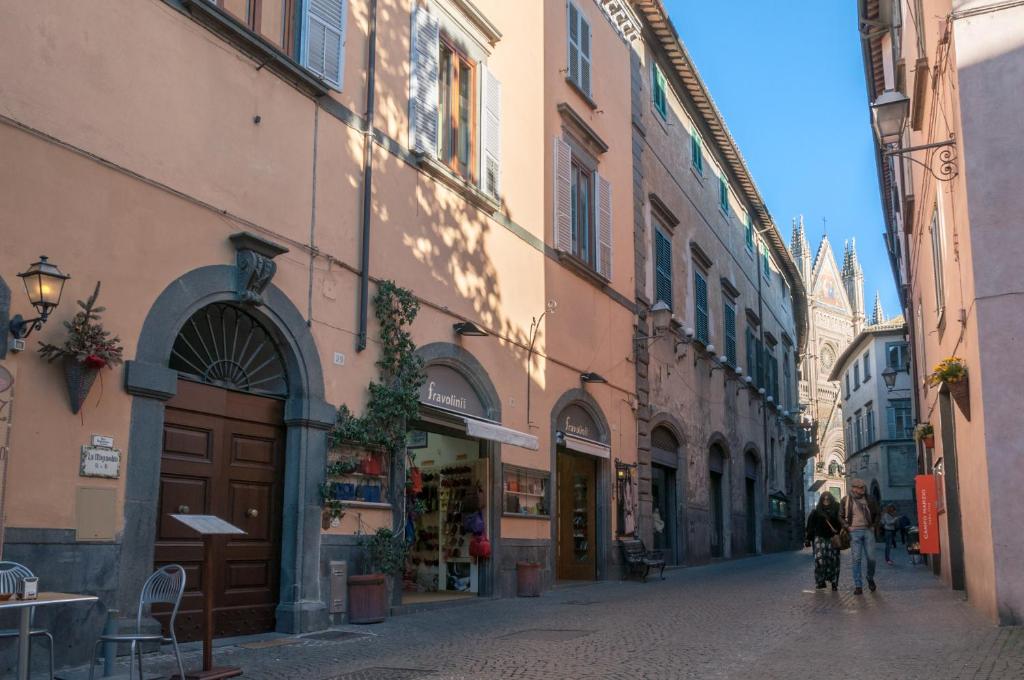 オルヴィエートにあるAppartamento la Piazzettaの建物と自転車に乗る人が並ぶ狭い道