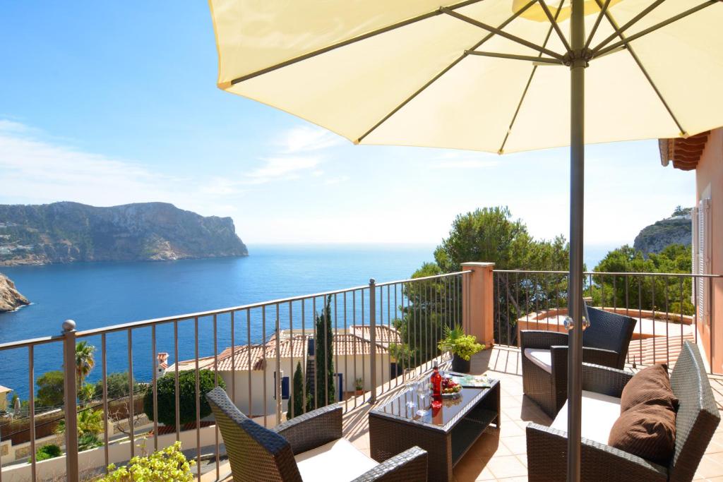 a balcony with an umbrella and a view of the ocean at Sea Views Villa with Pool Port Andratx in Port d'Andratx