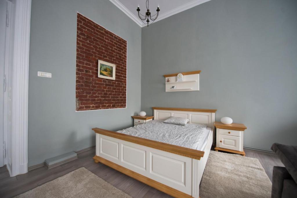 a bedroom with a bed and a brick wall at Apartament Maria in Timişoara