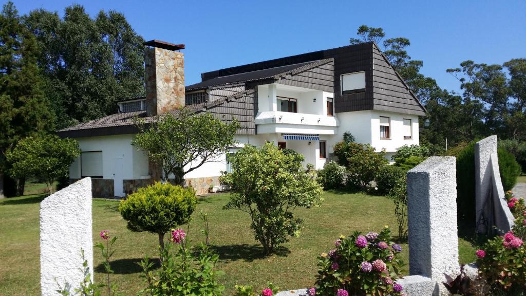 a white house with a black roof at Casa Rural Caserío el Molín in La Caridad