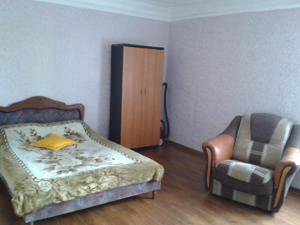 キスロヴォツクにあるApartment on Karla Marksa 8のベッドルーム1室(ベッド1台、椅子付)
