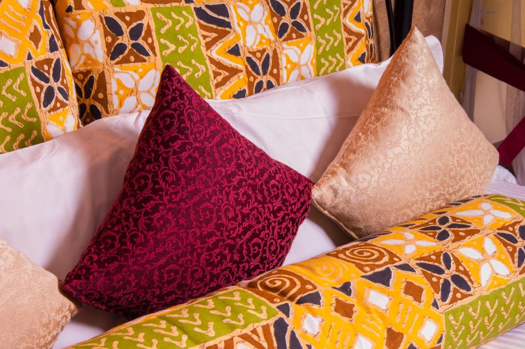 a group of pillows sitting on a bed at Kahama Hotel Nairobi in Nairobi