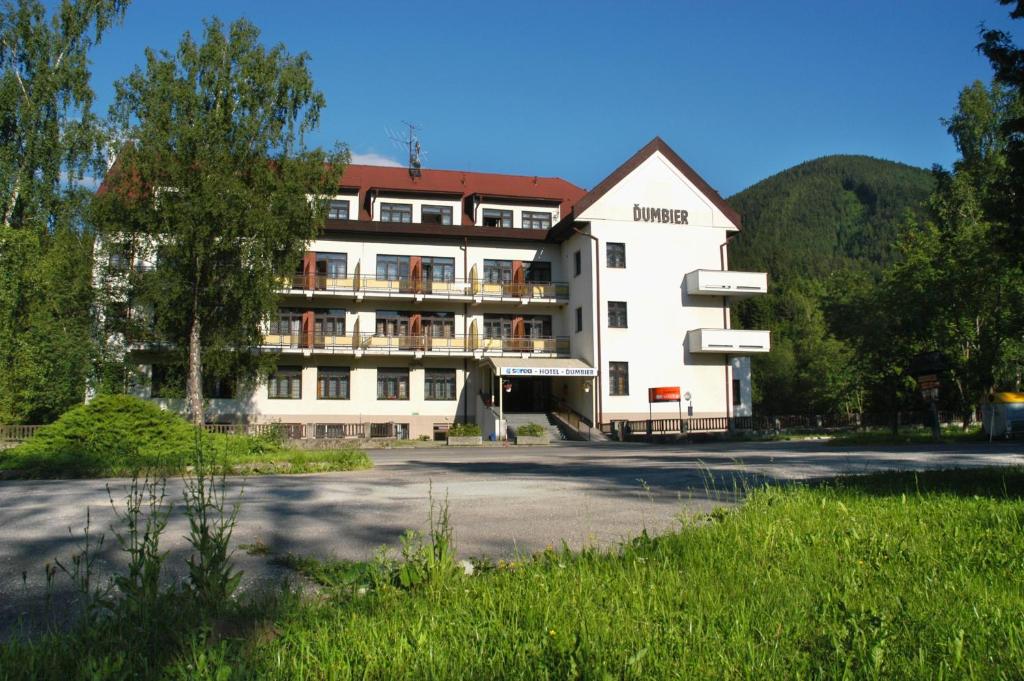 un gran edificio blanco con techo rojo en Hotel SOREA ĎUMBIER, en Liptovský Ján