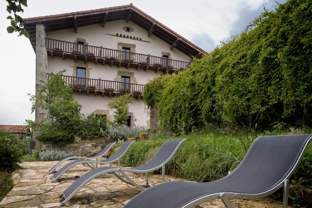 un grupo de sillas sentadas frente a un edificio en Hotel Akerreta, en Akerreta