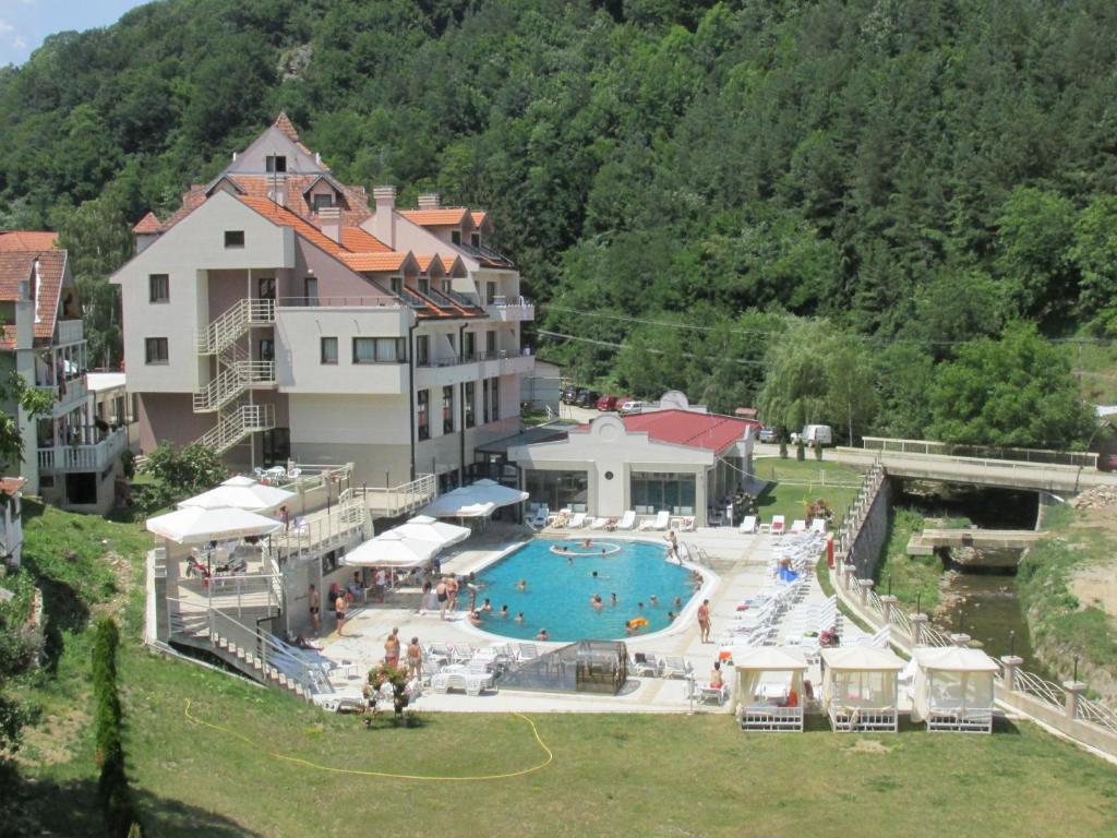 ein Hotel mit einem Schwimmbad vor einem Gebäude in der Unterkunft Hotel Kopaonik Lukovska Banja in Lukovo