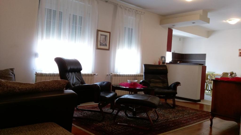ein Wohnzimmer mit Ledersesseln und einem Tisch in der Unterkunft Apartment Krsmanovic in Aranđelovac