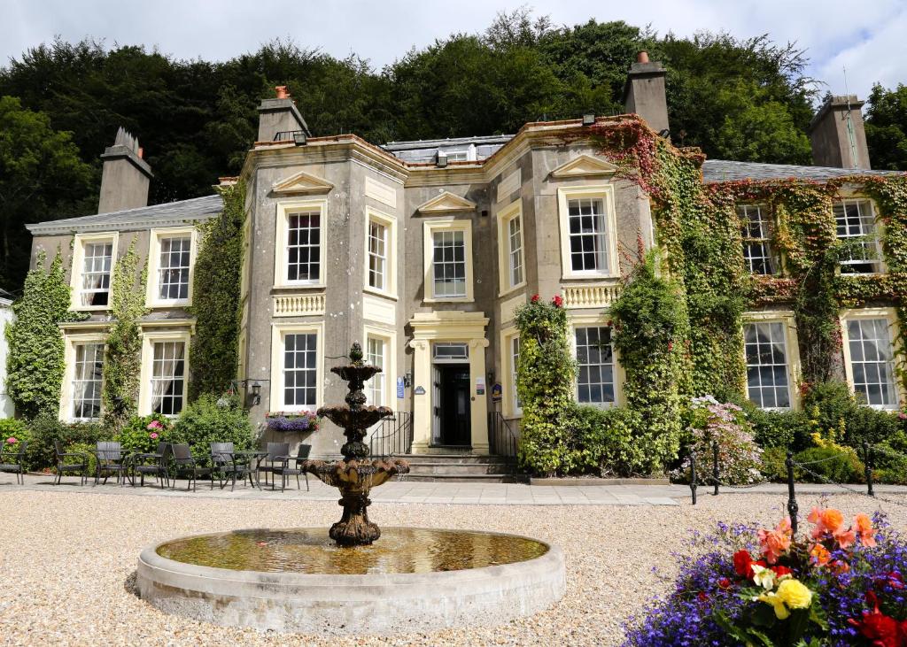 a large house with a fountain in front of it at New House Country Hotel in Cardiff