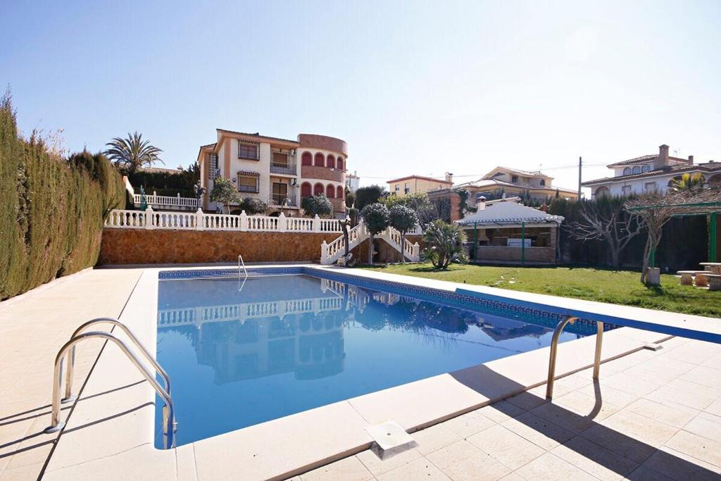 una gran piscina en un patio con casas en Villa Nazari, en Otura