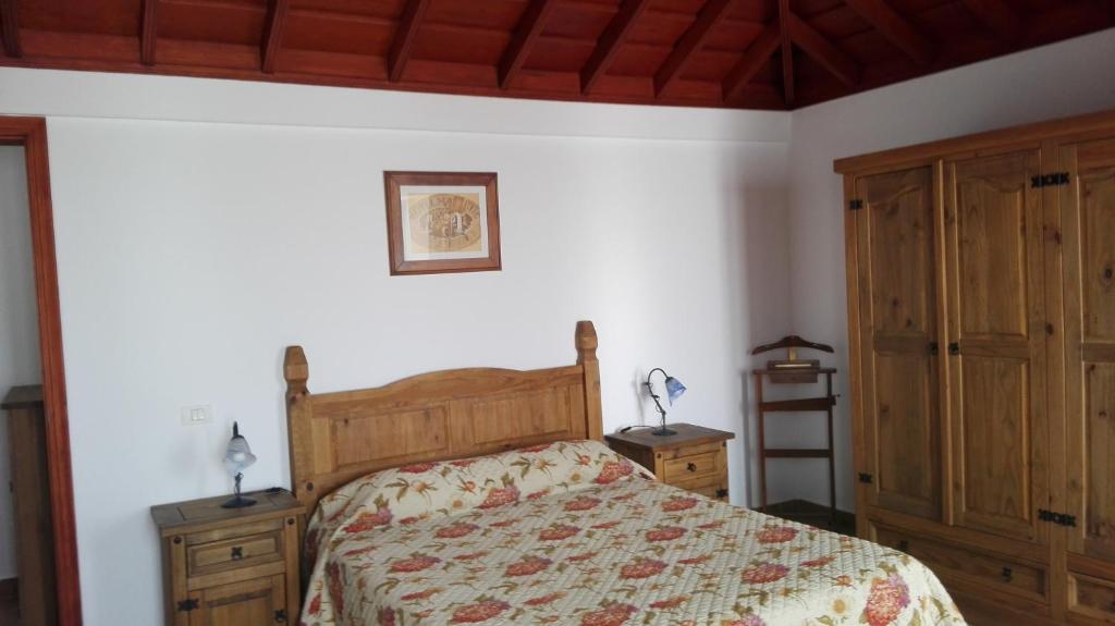 1 dormitorio con 1 cama y 2 armarios de madera en Casa Clara, en Fuencaliente de la Palma