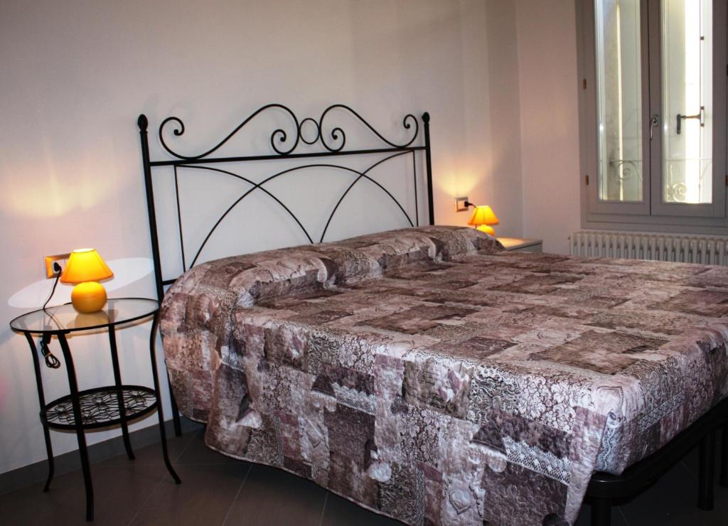 コマッキオにあるAppartamento Borghettoのベッドルーム1室(大型ベッド1台、テーブル2台付)