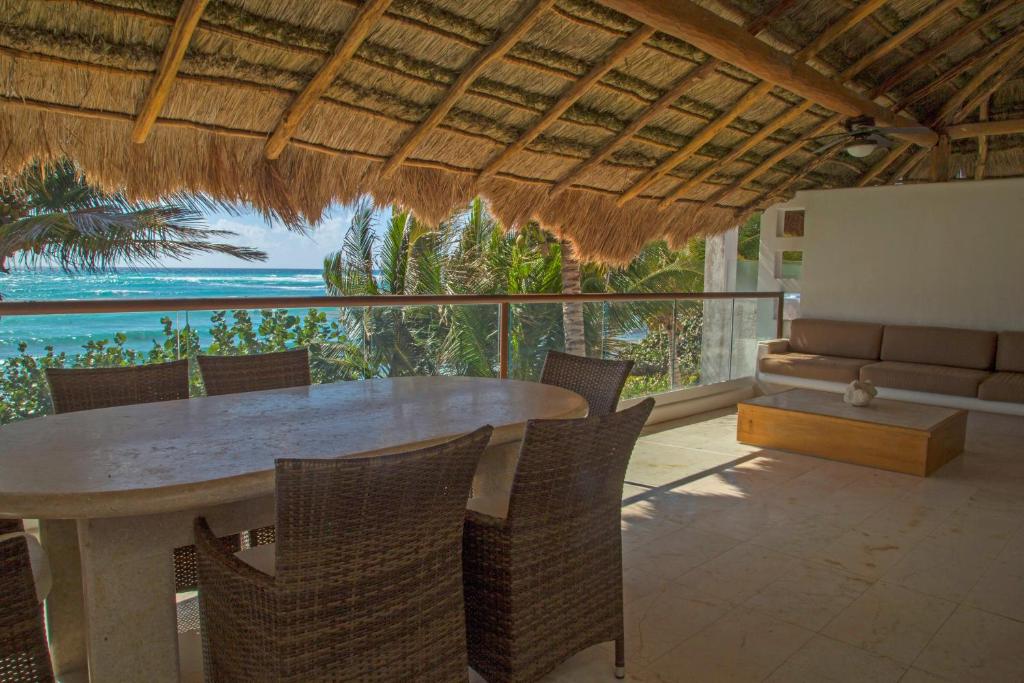 a dining room with a table and chairs and the ocean at Las Villas Akumal in Akumal