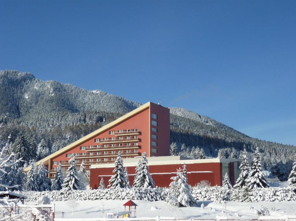 a hotel in the snow in front of a mountain at Hotel SOREA MÁJ in Liptovský Ján