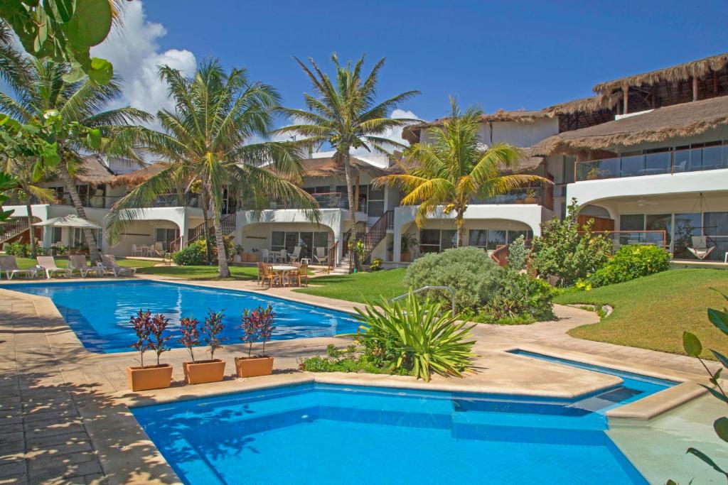 a swimming pool in front of a resort at Las Villas Akumal in Akumal