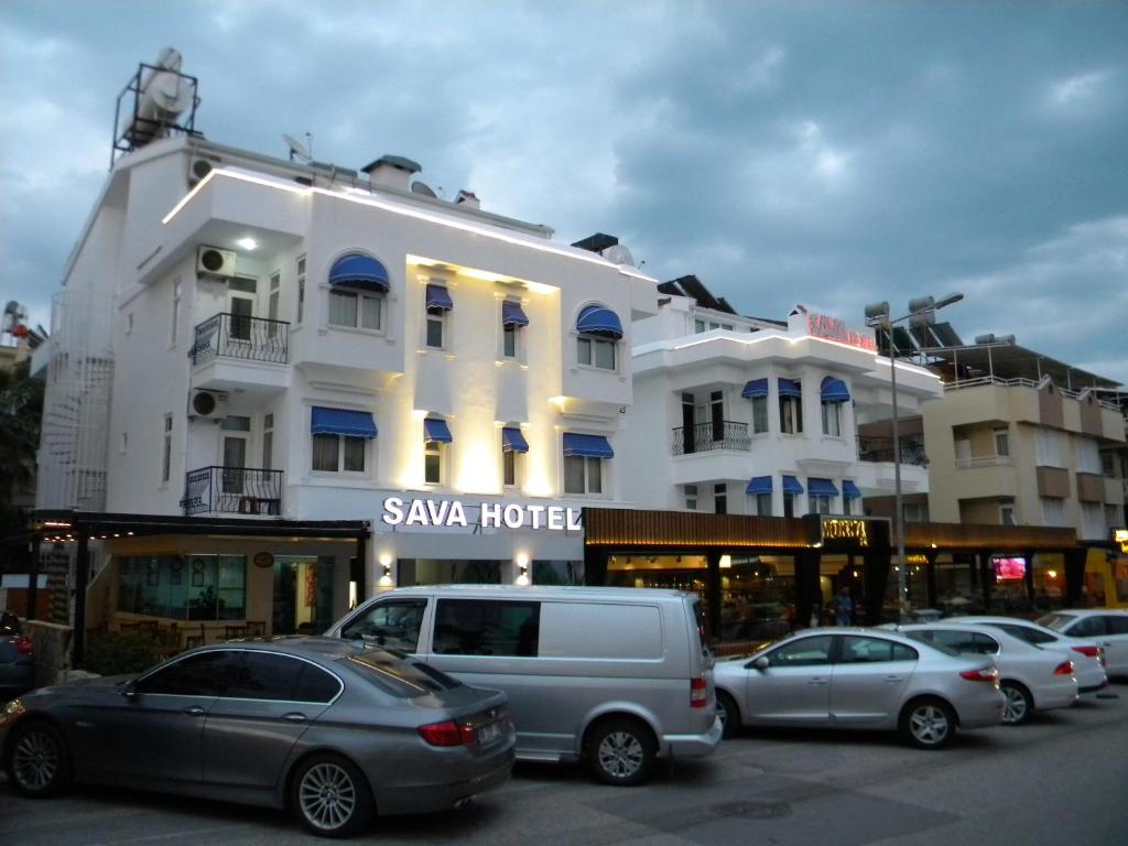 een groep auto's geparkeerd voor een gebouw bij Sava Hotel in Antalya