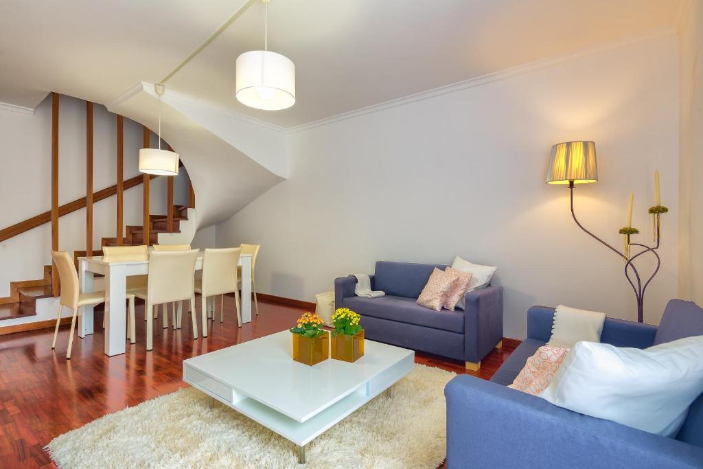 uma sala de estar com um sofá azul e uma mesa em Golden Place Apartment no Funchal