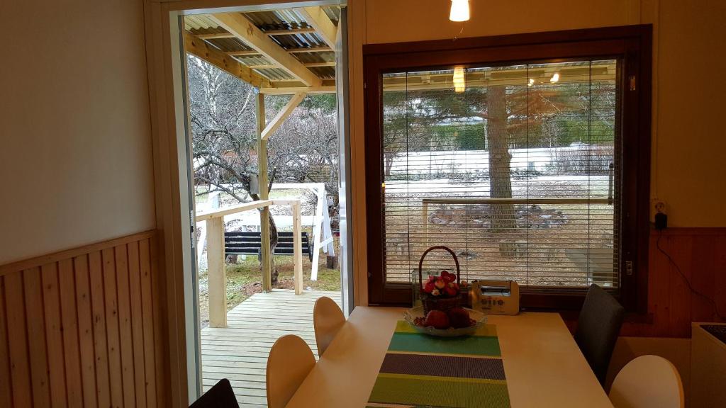 a dining room with a table and a large window at Naantali Holiday Home in Naantali