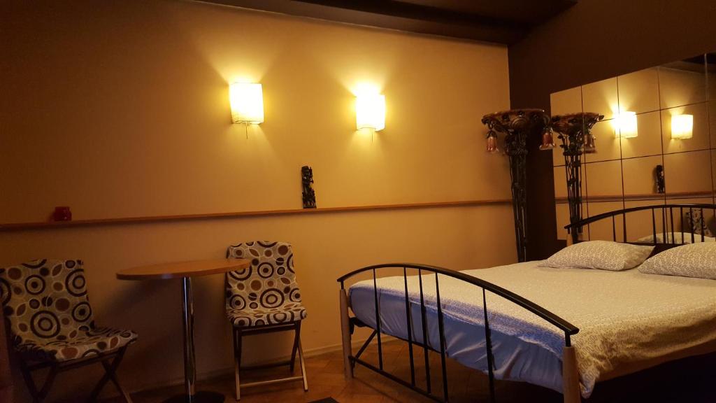 a bedroom with a bed and a table and chairs at Hospitality Centrum- River in Bucharest