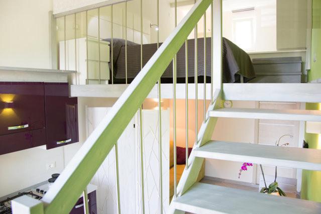 a staircase with a green railing in a room at Mini Loft Fronte Mare in Pescara