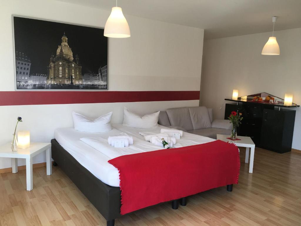 a bedroom with a large bed and a couch at Hotel & Apartments Altstadtperle in Dresden