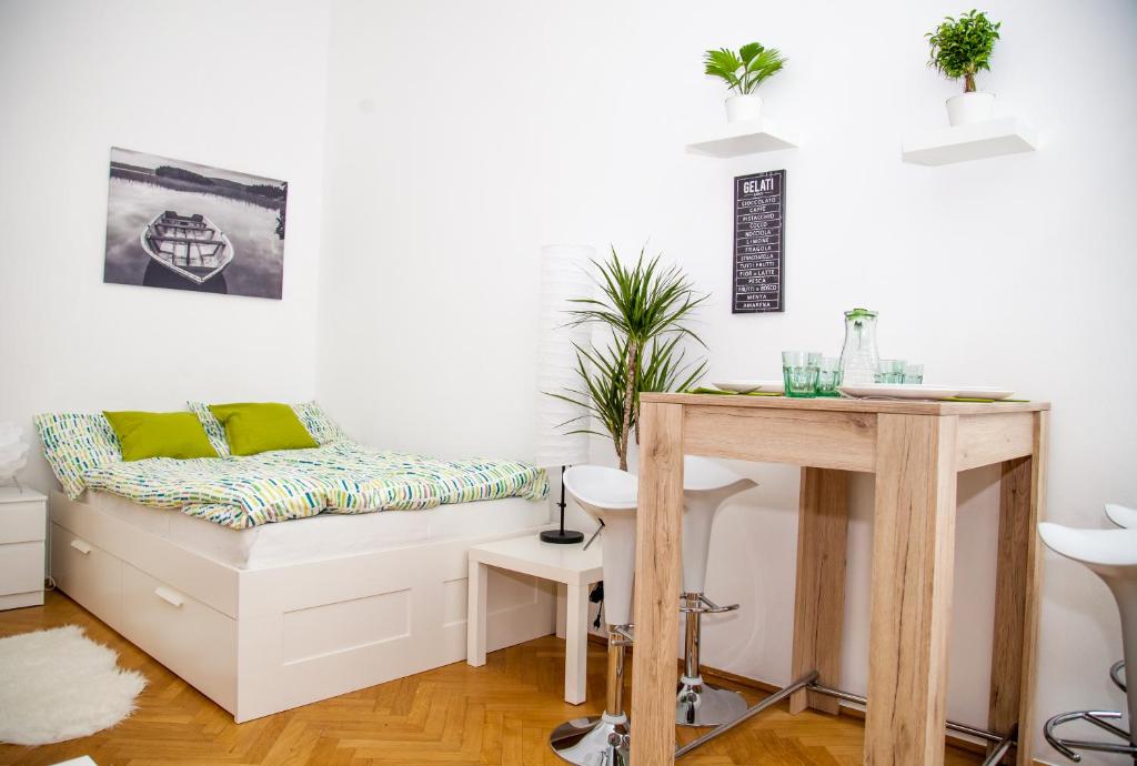 biały pokój z łóżkiem i stołem w obiekcie Vienna Lights Apartments - Karmarschgasse w Wiedniu