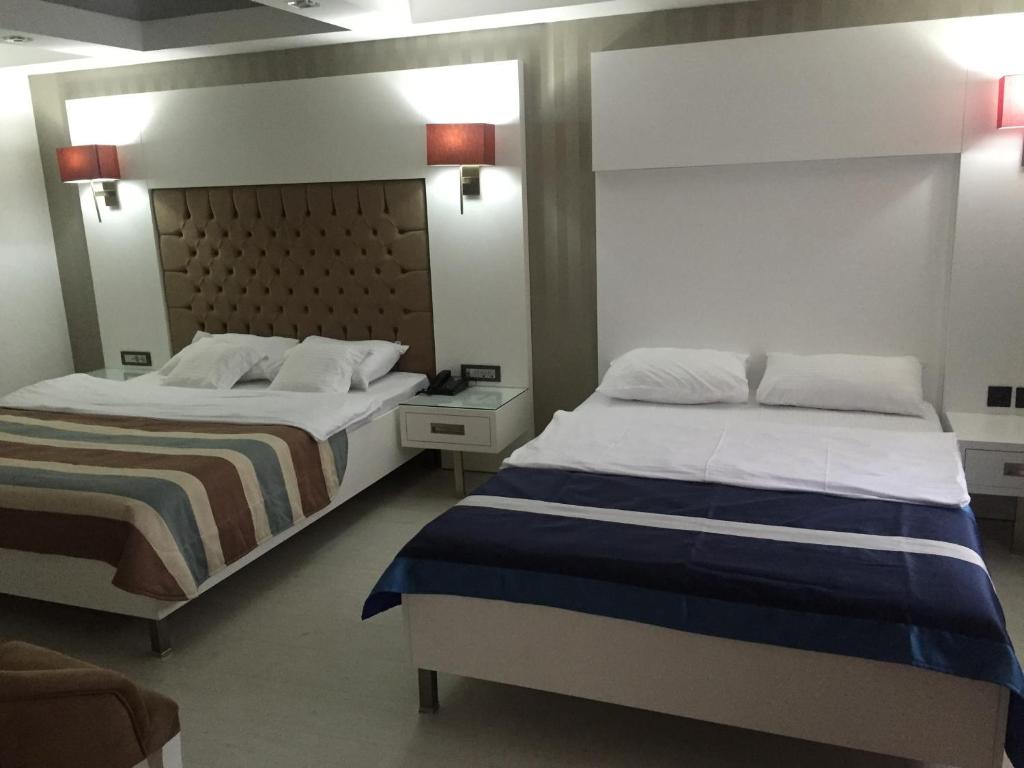 サムスンにあるSamsun Sahin Hotel 2のベッド2台(サイドサイドサイド)が備わるホテルルーム内のベッド2台