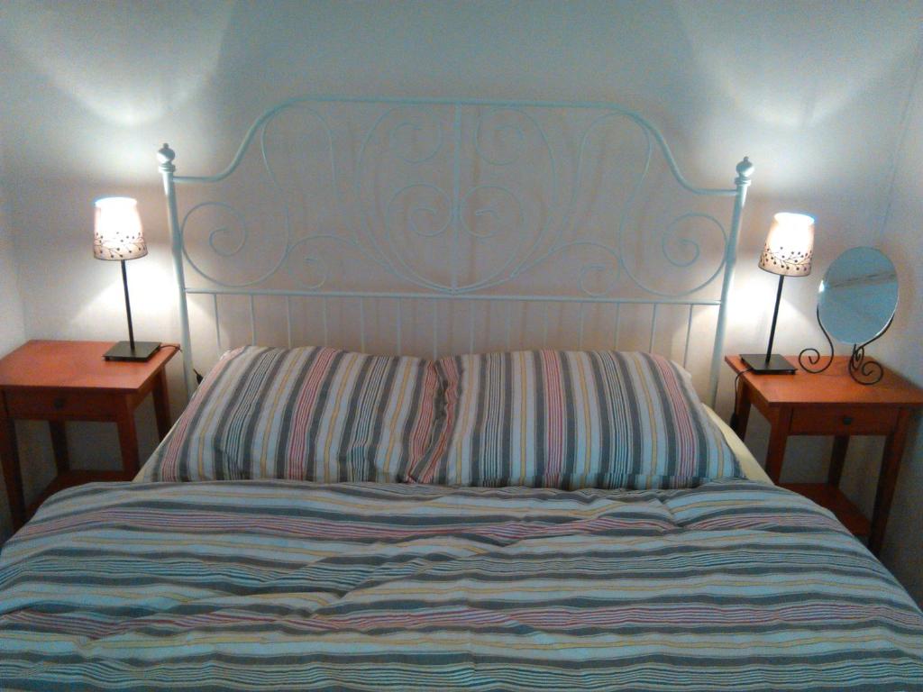 een slaapkamer met een bed met 2 tafels en 2 lampen bij Pension Behnisch in Strehla