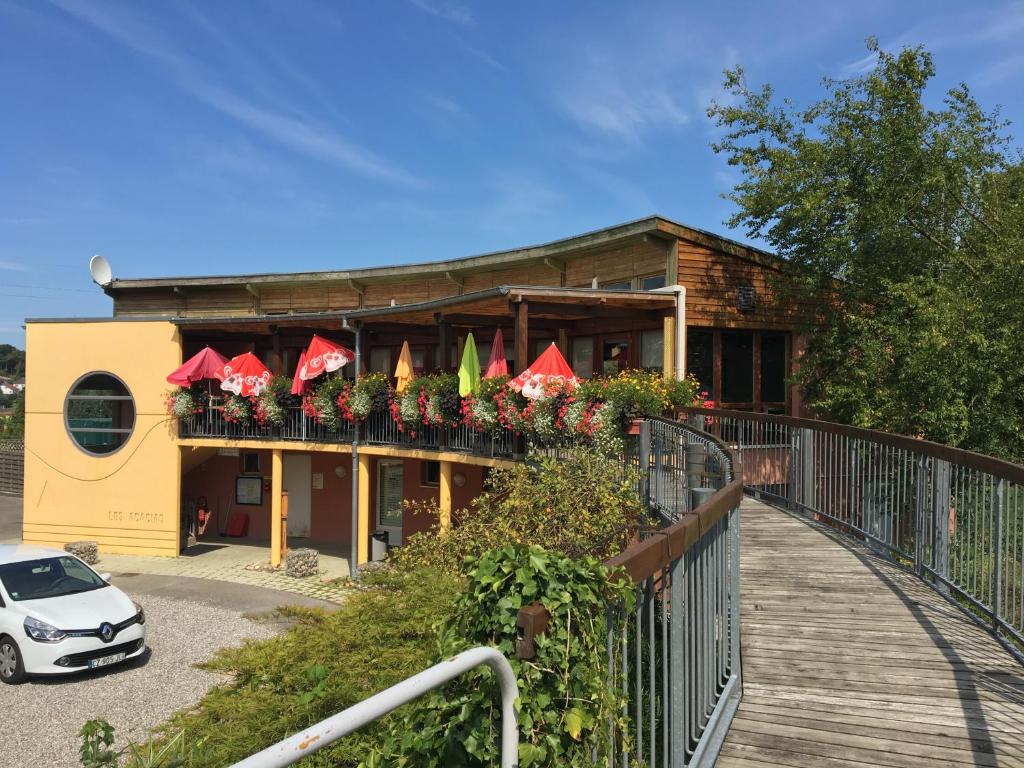 un bâtiment avec une voiture garée devant lui dans l'établissement Camping les Acacias, à Altkirch