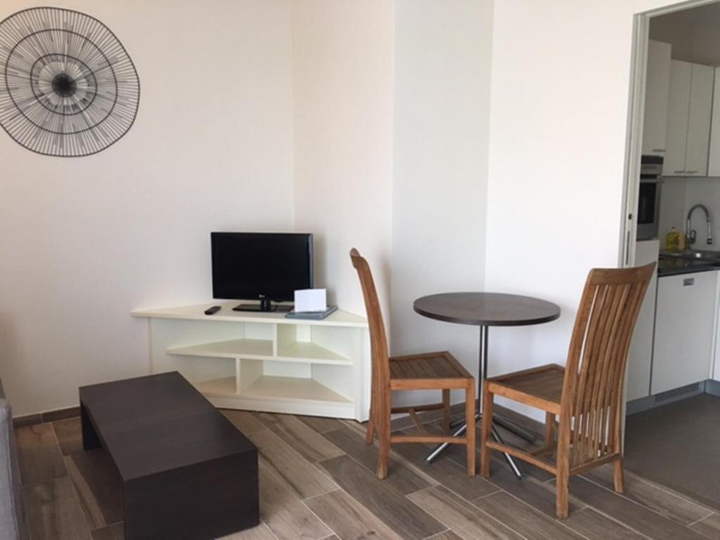 Habitación con mesa, sillas y escritorio con ordenador. en Arthur Properties Bel Air, en Cannes