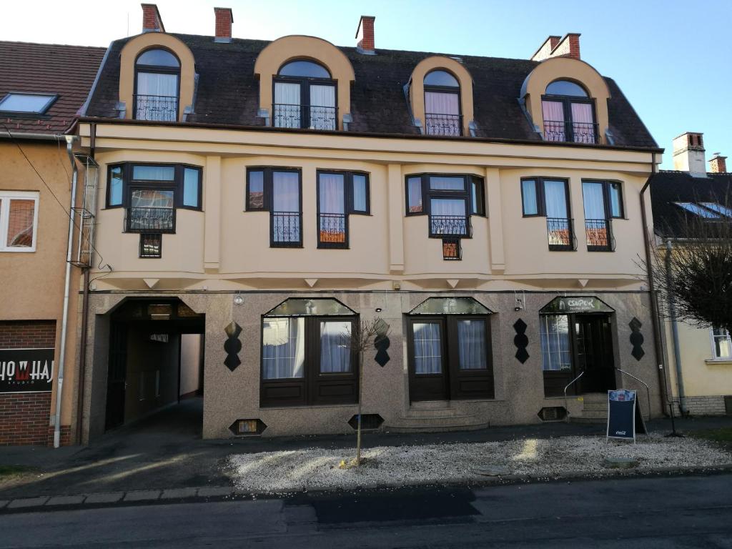 un gran edificio con puertas y ventanas negras en Mátyás Szállás, en Szombathely