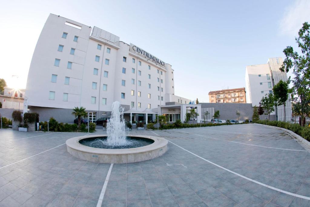 une fontaine dans une cour en face d'un bâtiment dans l'établissement Centrum Palace Hotel & Resorts, à Campobasso