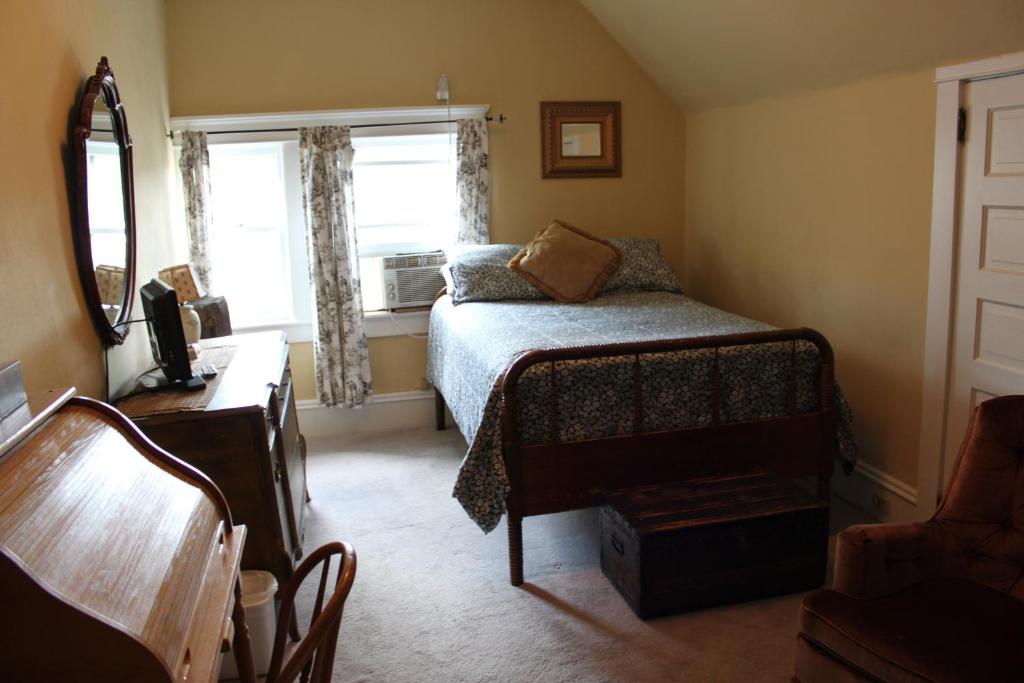 una piccola camera da letto con un letto e una finestra di Victorian Charm Inn a Towanda