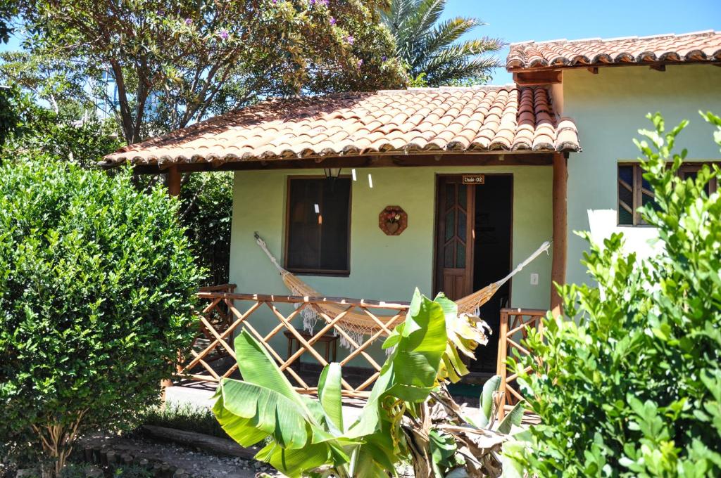 uma pequena casa branca com telhado de azulejo vermelho em Pousada e Hostel Pé no Mato em Vale do Capao