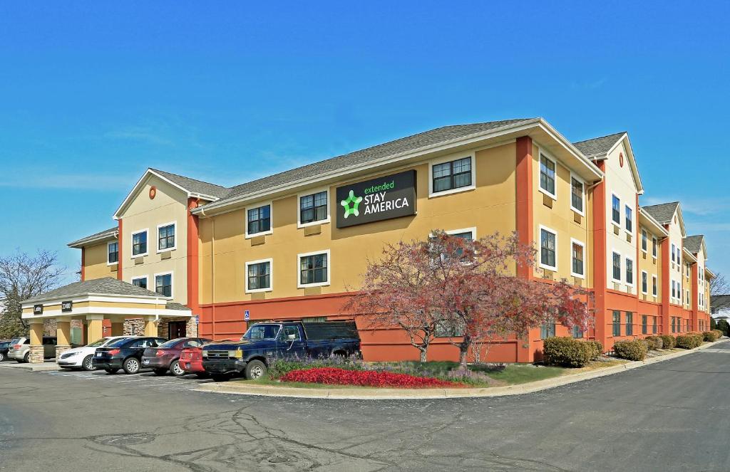 un edificio de hotel con coches aparcados en un aparcamiento en Extended Stay America Select Suites - Detroit - Sterling Heights en Sterling Heights