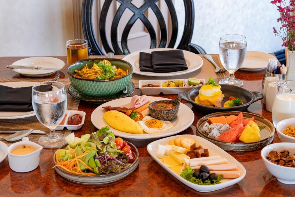 A generously arranged breakfast table with hot dishes, fruit, salads and pastries.