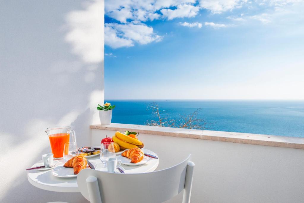 una mesa con comida y vistas al océano en Casa Malu en Positano